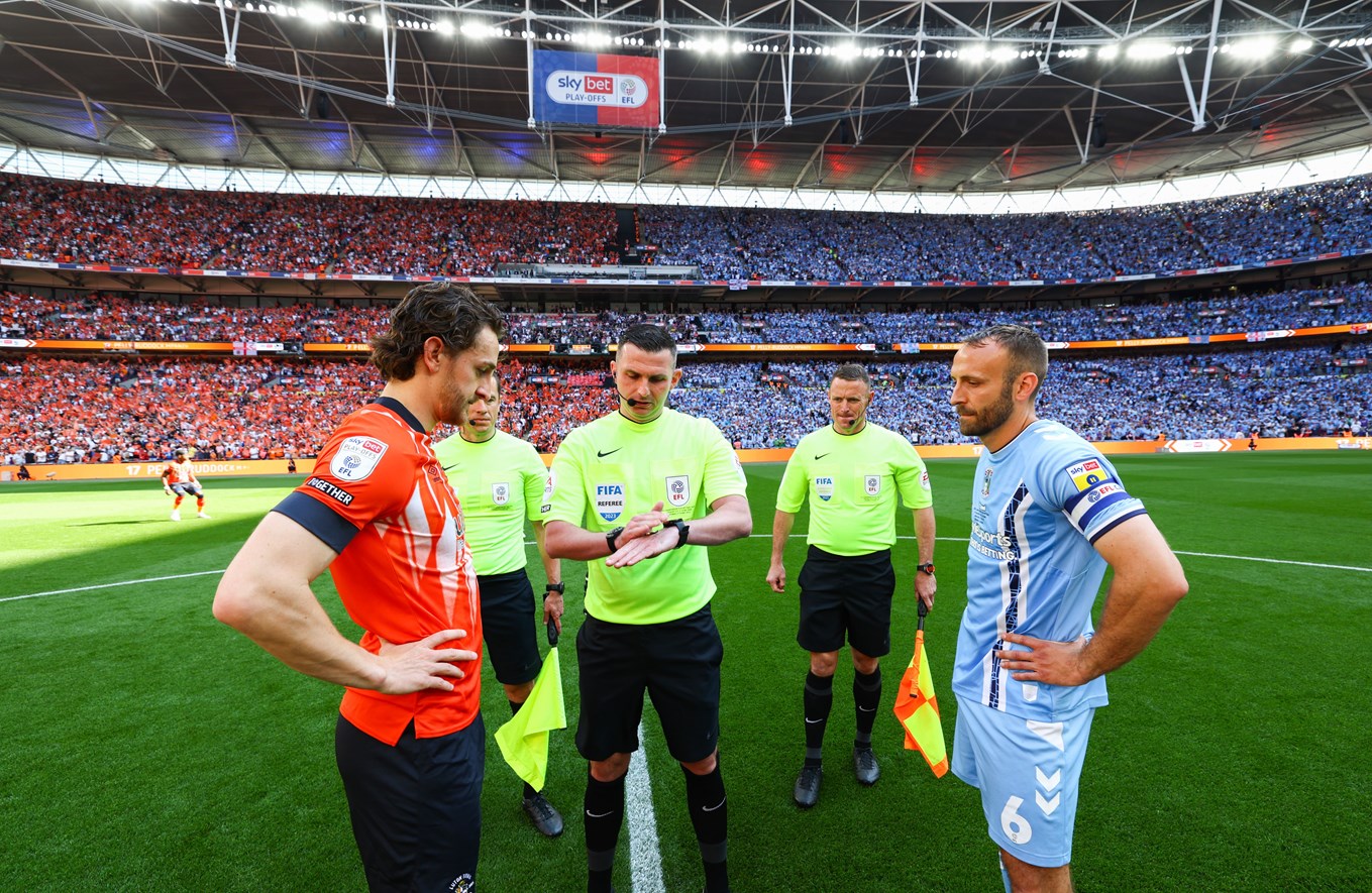 Michael Oliver stood with Tom Lockyer and Liam Kelly performing the coin toss at Wembley.