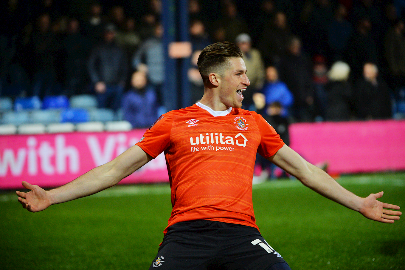 Reece Burke knee-slides after putting Luton Town in the lead against Chelsea.