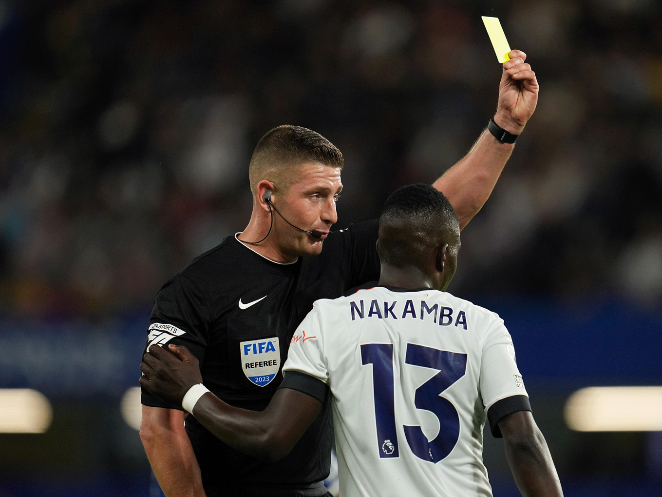Robert Jones handing Marvelous Nakamba a yellow card at Stamford Bridge in August 2023.