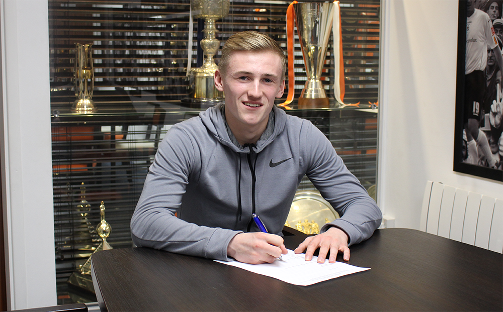 England Under-19 midfielder Flynn Downes signs his loan deal in the Kenilworth Road Trophy Room