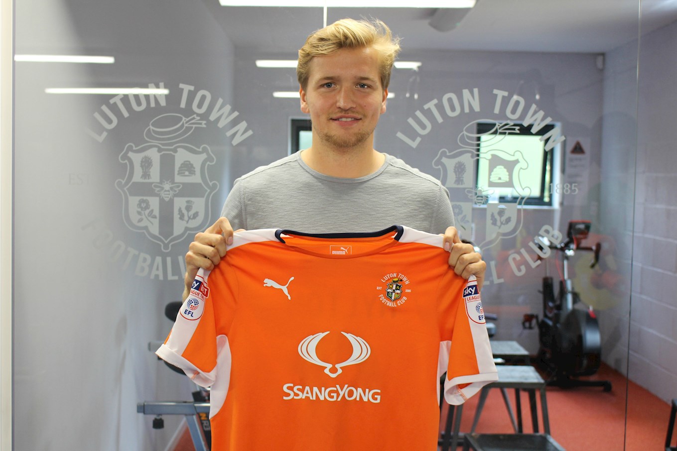 Luke Berry holds up the Hatters shirt after signing in August 2017