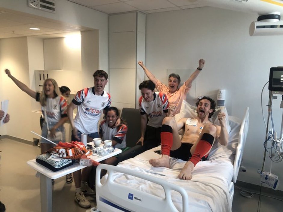 Tom Lockyer celebrates the Hatters' play-off final win in hospital with his family