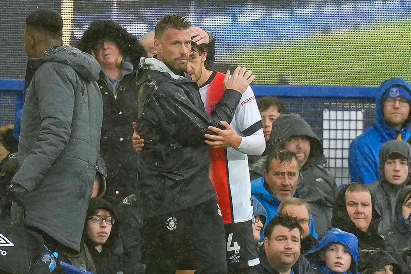 Tom Lockyer being hugged by Rob Edwards after being forced off at Everton.