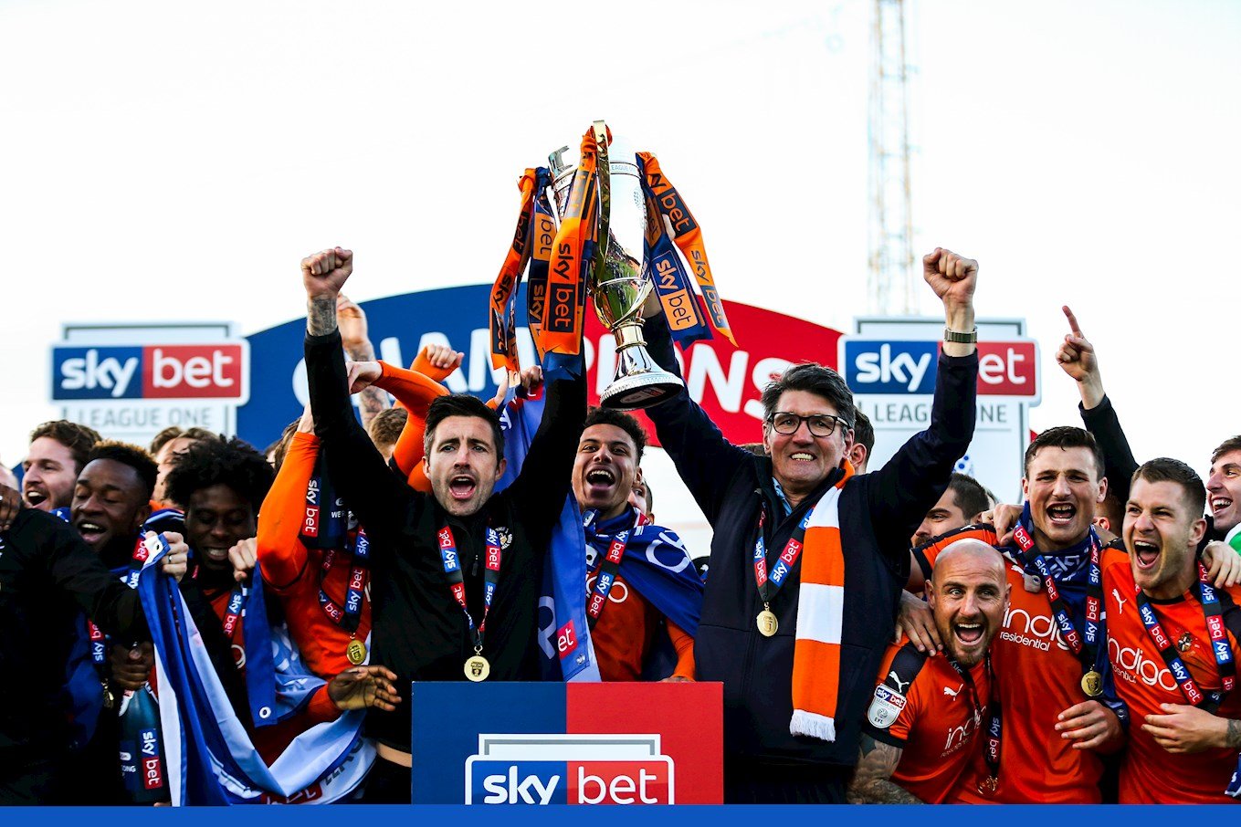 Club captain Sheehan and interim manager Mick Harford lift the League One trophy at the end of the 2018-19 season