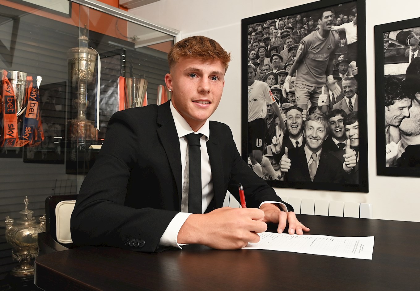 Josh Allen signs his contract in the Trophy Room at Kenilworth Road