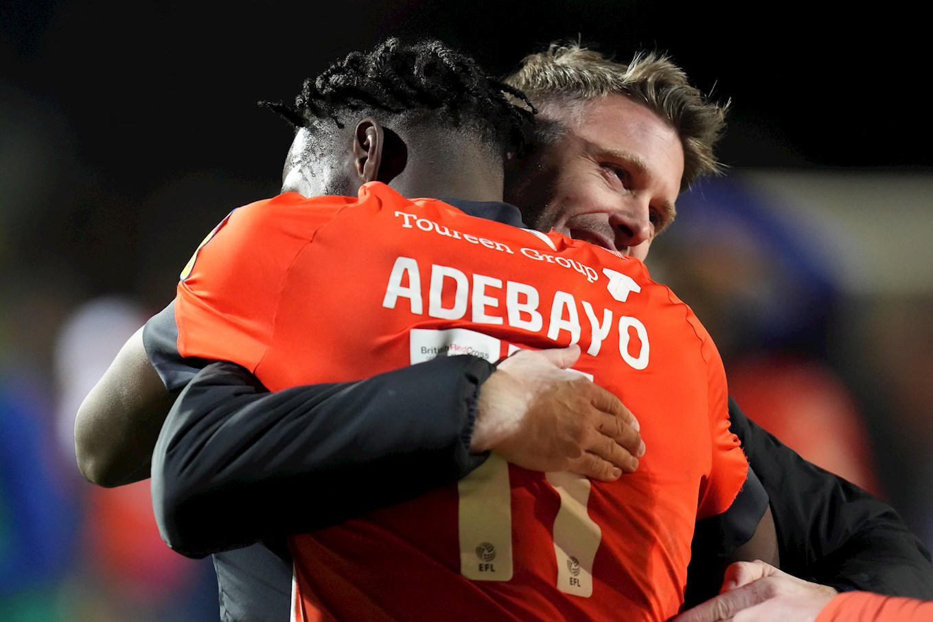 Elijah Adebayo gets a post-match hug from manager Rob Edwards